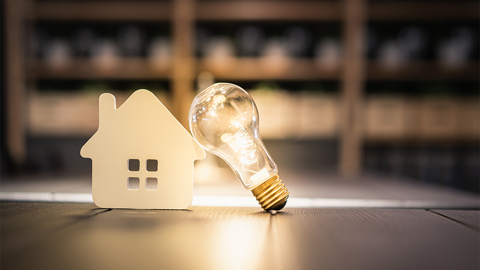 Light bulb and wood house on a table